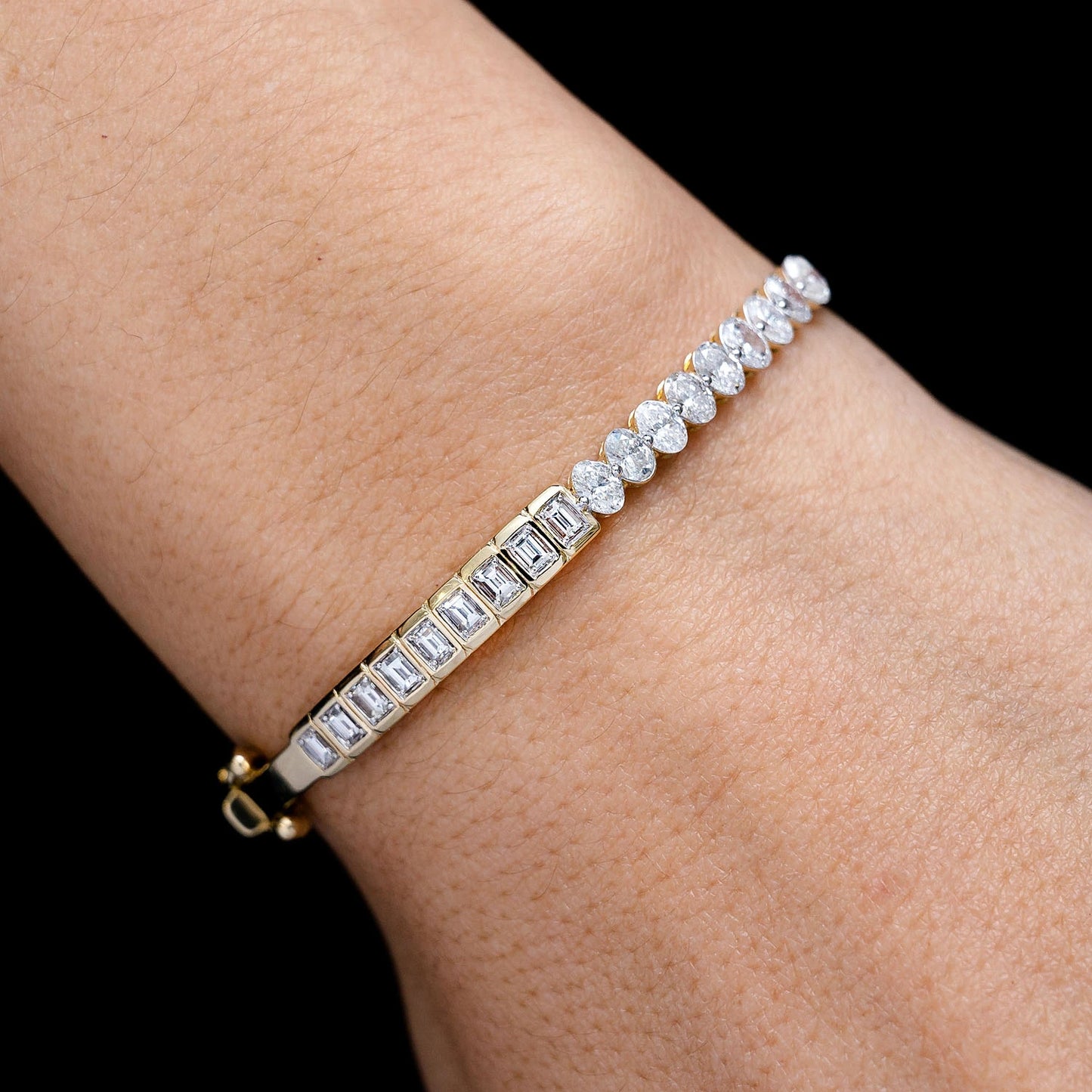Bezel Baguette & Oval Diamond Bangle Bracelet in 14K yellow gold, angled view
