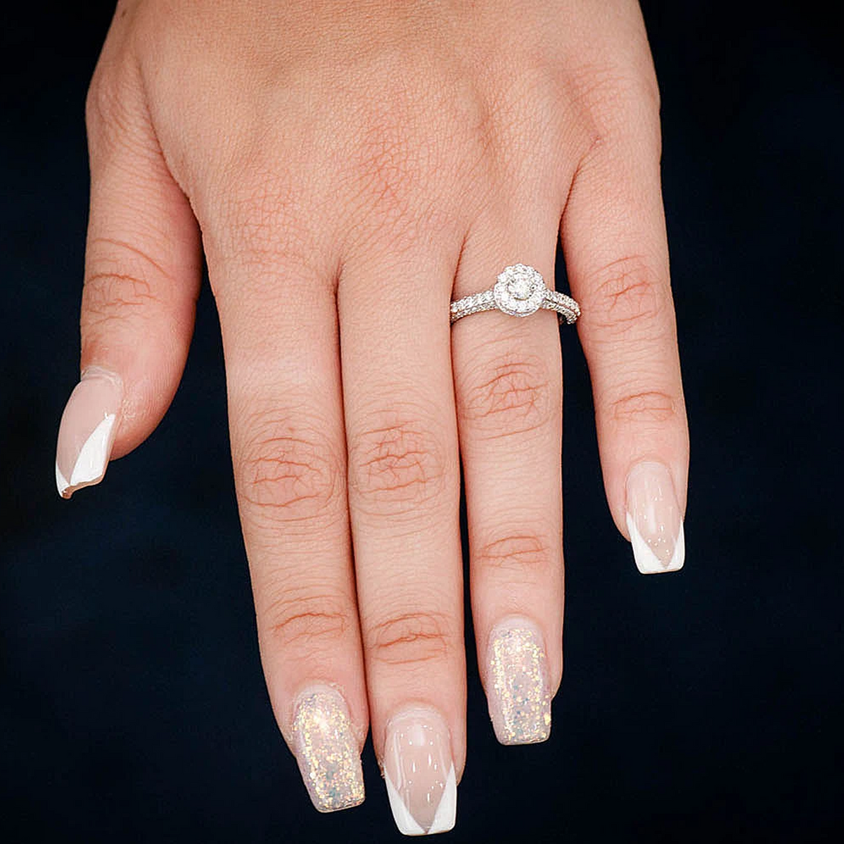 Halo and pave engagement ring in 14K white gold, worn on hand